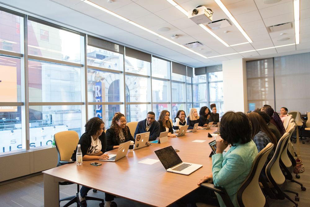 A team working on laptops around a long boardroom table